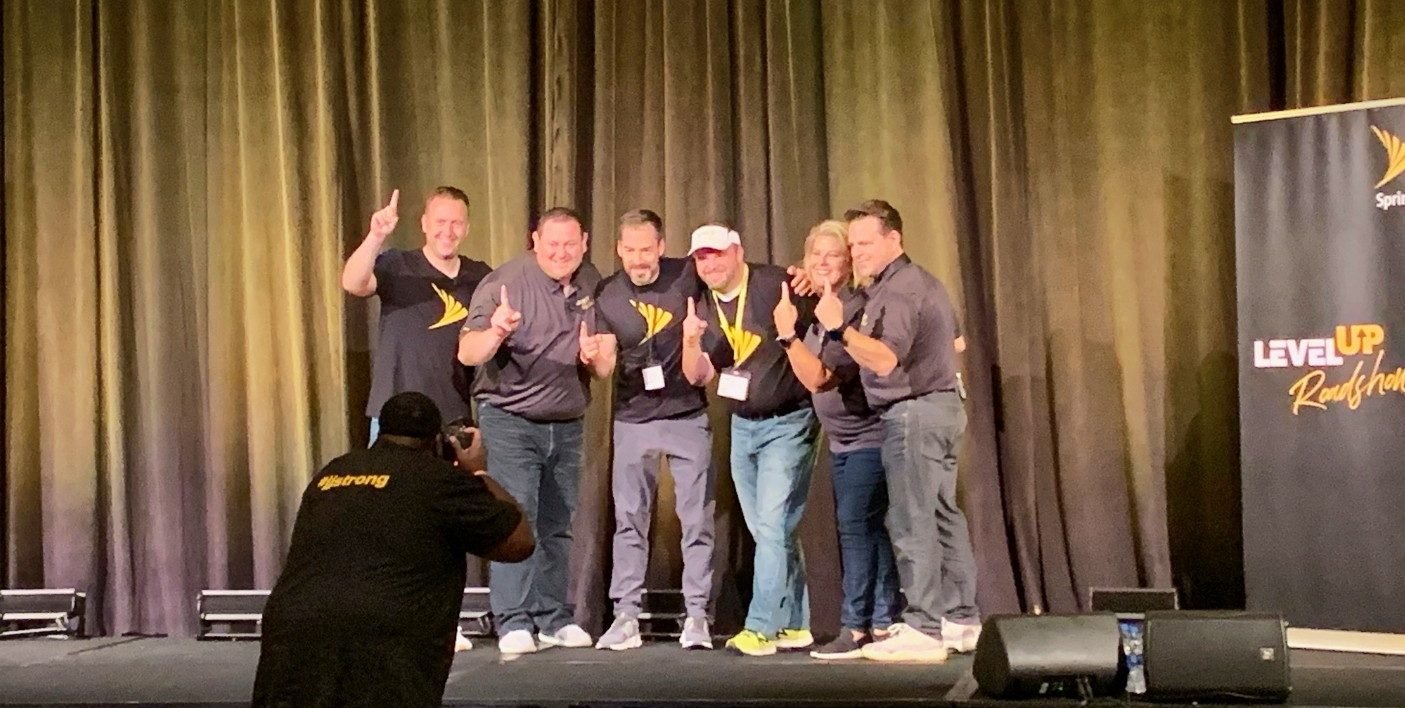 Jim Cripps and his leadership team celebrating on stage at an industry event